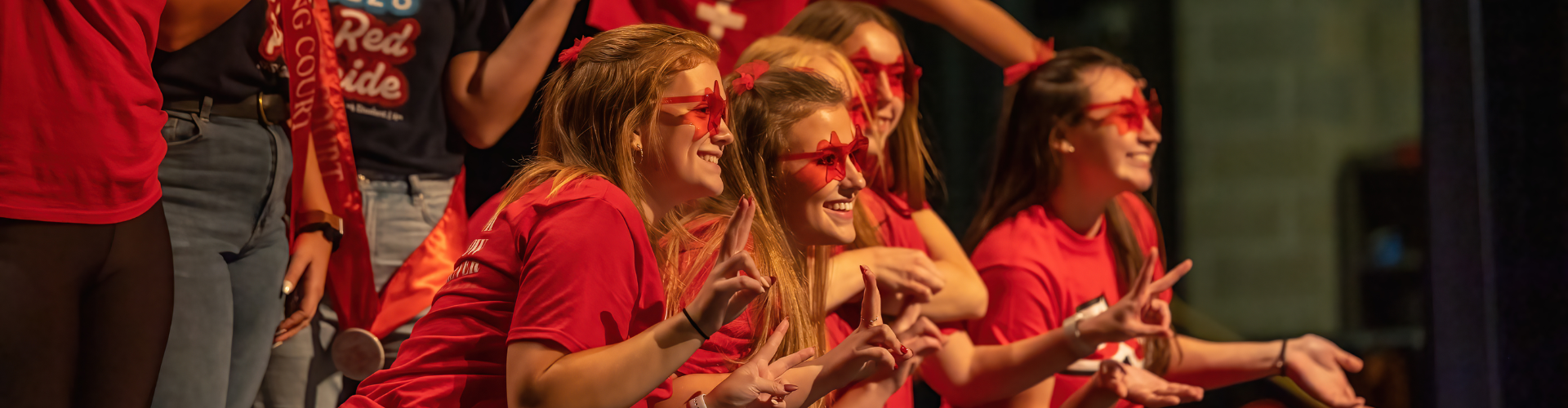 Students posing on stage in the Malcolm Field Theatre after concluding their lip sync performance.